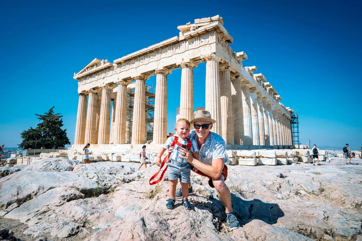 Family posing in front of the Parthenon, capturing the experience of visiting Greece with a toddler.
